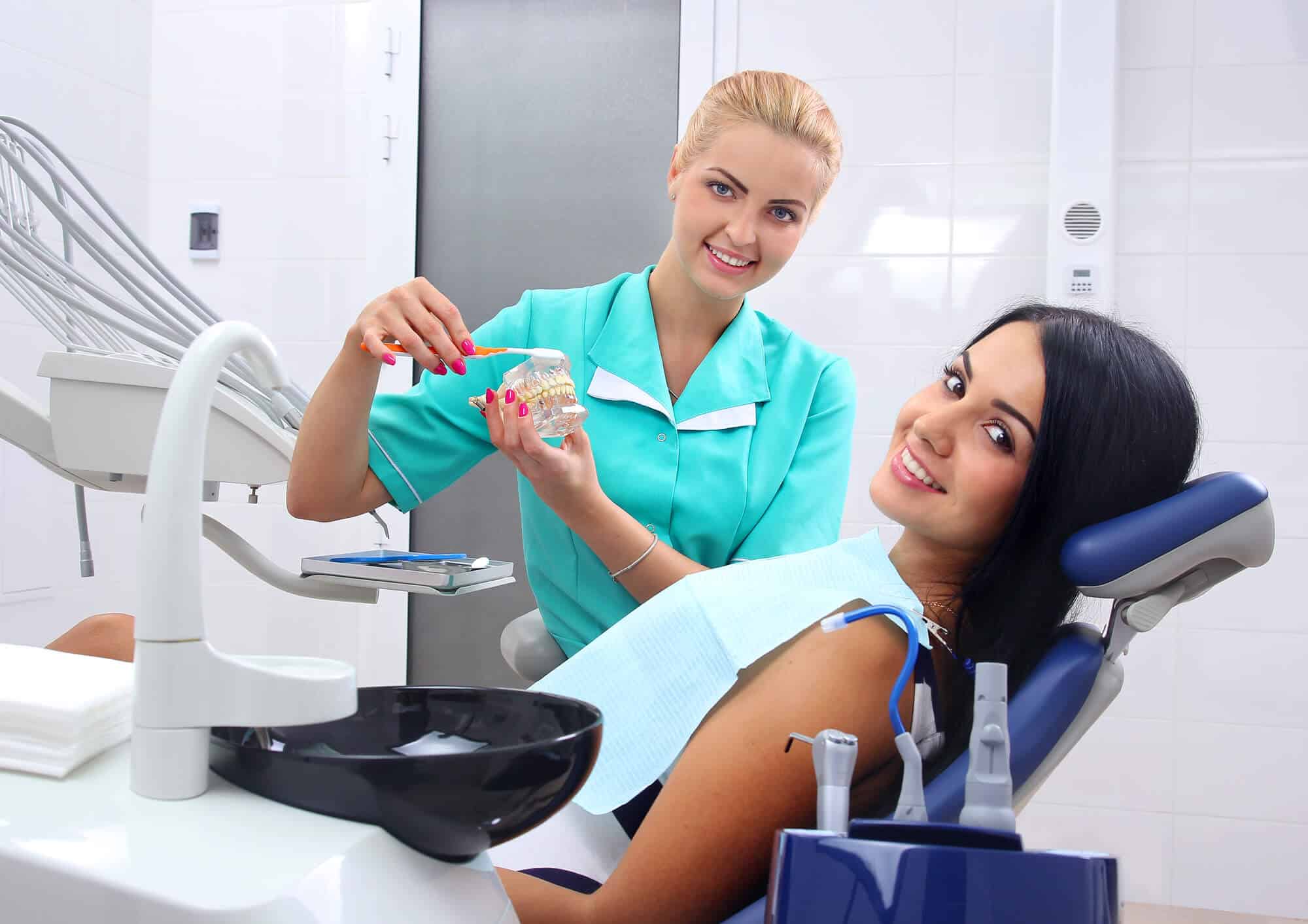 dentist showing patient how to care for dental bridges wilmington